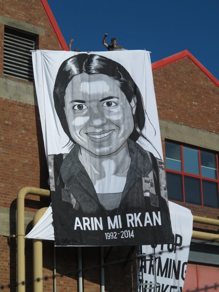 arin mirkan's face painted on a long thin banner in black and white
